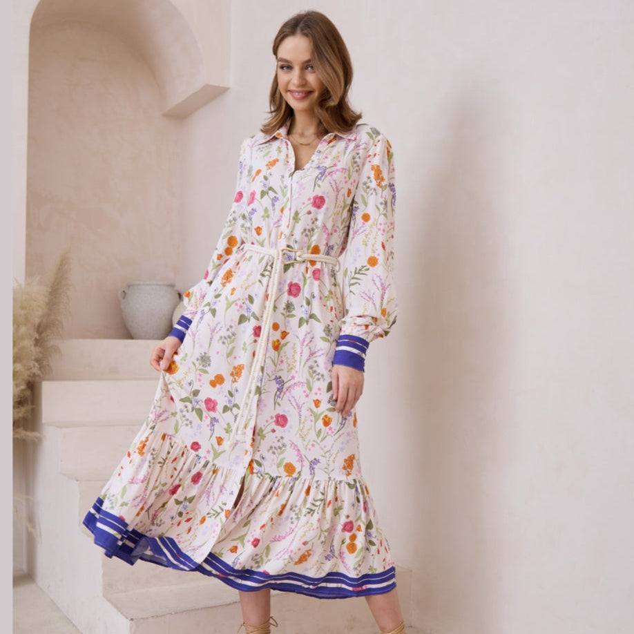 Woman wearing a floral dress with blue accents in a bright interior setting